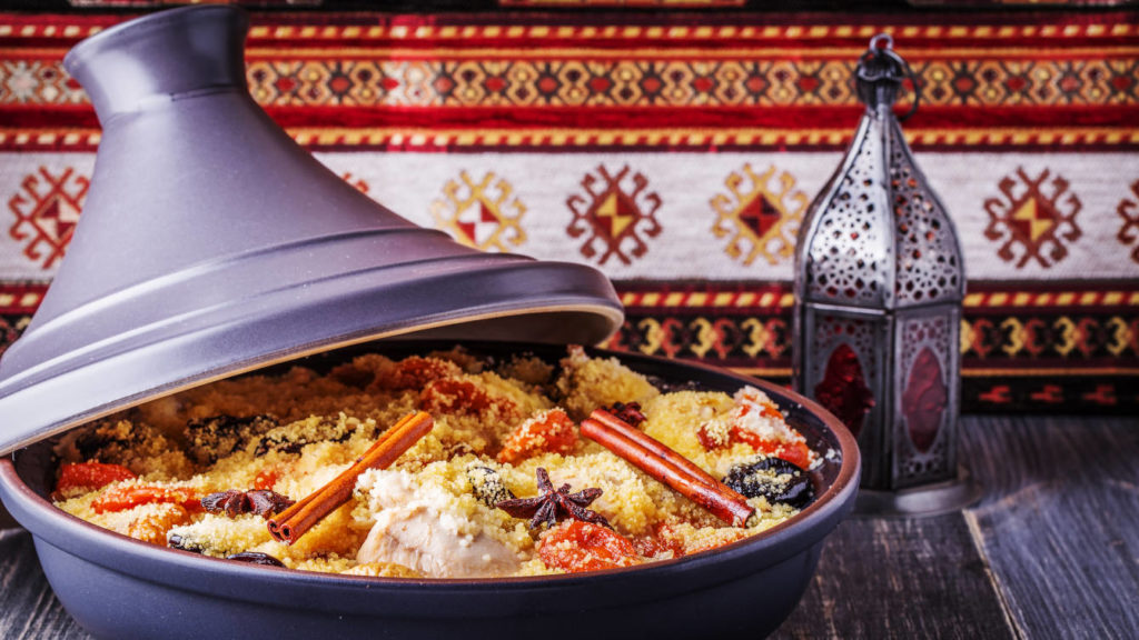 Tajine traditionnel marocain de poulet aux fruits secs et épices, focus sélectif.